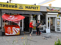 Two women are talking outside a shop damaged by the Russian missile attack in central Vilniansk, Zaporizhzhia region, southern Ukraine, on J...