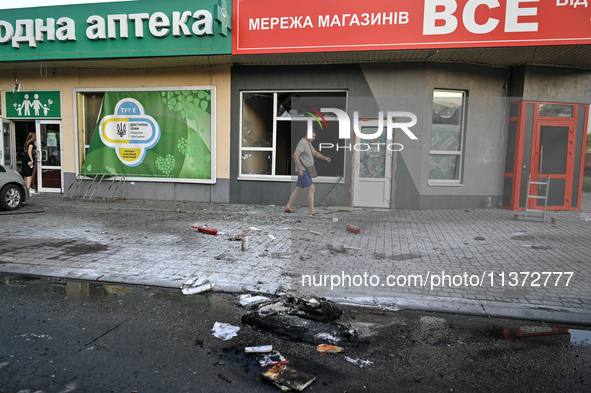 A man is walking past a shop damaged by the Russian missile attack in Vilniansk, Ukraine, on June 29, 2024. Russia is launching rockets at t...