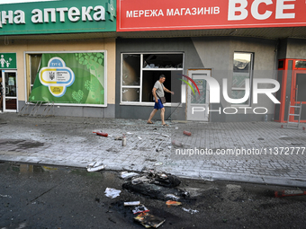 A man is walking past a shop damaged by the Russian missile attack in Vilniansk, Ukraine, on June 29, 2024. Russia is launching rockets at t...