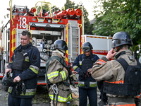 Rescuers are standing by a fire engine during a response effort to the Russian missile attack in central Vilniansk, Zaporizhzhia region, sou...