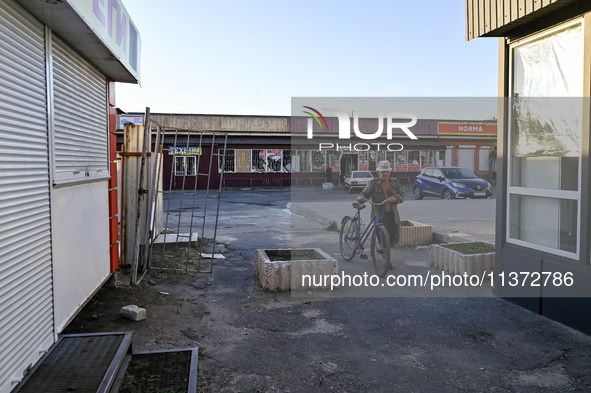 A man is pushing a bicycle at a market near the scene of the Russian missile attack in central Vilniansk, Zaporizhzhia region, southern Ukra...