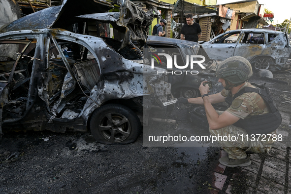 A criminal expert is examining a car destroyed by the Russian missile strike in central Vilniansk, Zaporizhzhia region, southern Ukraine, on...