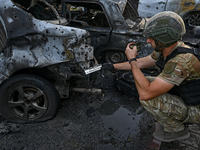 A criminal expert is examining a car destroyed by the Russian missile strike in central Vilniansk, Zaporizhzhia region, southern Ukraine, on...