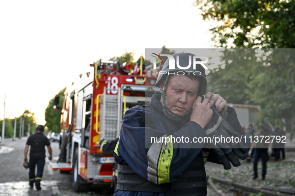 A rescuer is fixing his helmet during a response effort to the Russian missile attack in central Vilniansk, Zaporizhzhia region, southern Uk...