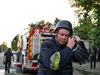 A rescuer is fixing his helmet during a response effort to the Russian missile attack in central Vilniansk, Zaporizhzhia region, southern Uk...