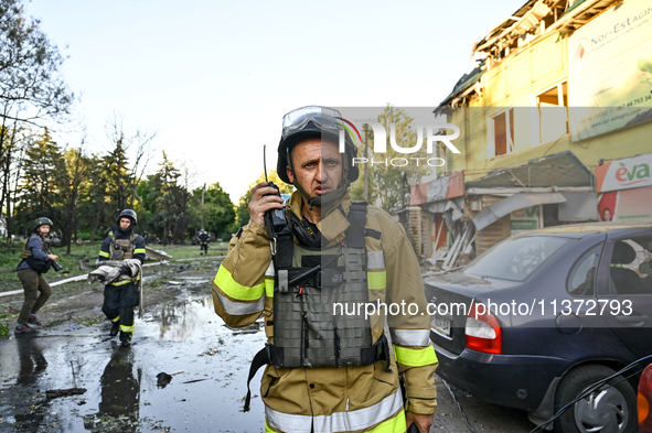 A rescuer is talking over a handheld transceiver during a response effort to the Russian missile attack in central Vilniansk, Zaporizhzhia r...