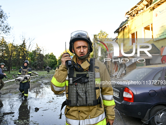 A rescuer is talking over a handheld transceiver during a response effort to the Russian missile attack in central Vilniansk, Zaporizhzhia r...