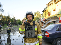 A rescuer is talking over a handheld transceiver during a response effort to the Russian missile attack in central Vilniansk, Zaporizhzhia r...