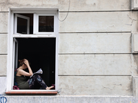 A reading person sits at a window in Krakow, Poland on June 30, 2024. (