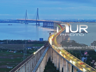 A photo taken on June 30, 2024, is showing the Shanghai-Suzhou-Nantong Yangtze River Railway Bridge in Nantong, China, on June 30, 2024. The...