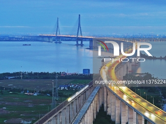 A photo taken on June 30, 2024, is showing the Shanghai-Suzhou-Nantong Yangtze River Railway Bridge in Nantong, China, on June 30, 2024. The...