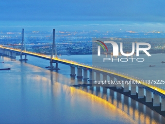 A photo taken on June 30, 2024, is showing the Shanghai-Suzhou-Nantong Yangtze River Railway Bridge in Nantong, China, on June 30, 2024. The...