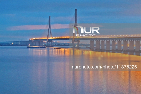 A photo taken on June 30, 2024, is showing the Shanghai-Suzhou-Nantong Yangtze River Railway Bridge in Nantong, China, on June 30, 2024. The...