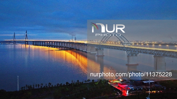 A photo taken on June 30, 2024, is showing the Shanghai-Suzhou-Nantong Yangtze River Railway Bridge in Nantong, China, on June 30, 2024. The...