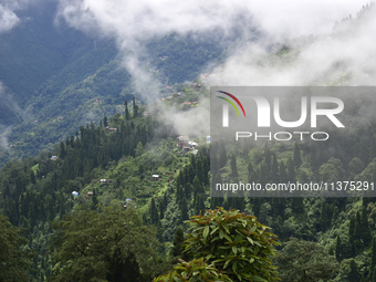 Small villages are being seen through clouds inside Singalila National Park in Darjeeling District, West Bengal, India, on June 29, 2024. (