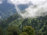 Small villages are being seen through clouds inside Singalila National Park in Darjeeling District, West Bengal, India, on June 29, 2024. (