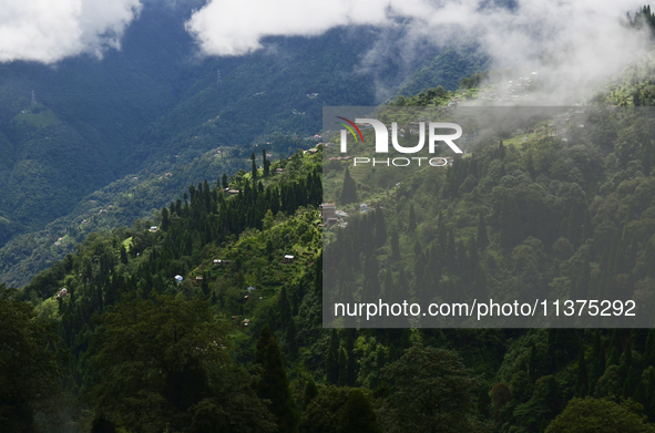 Small villages are being seen through clouds inside Singalila National Park in Darjeeling District, West Bengal, India, on June 29, 2024. 