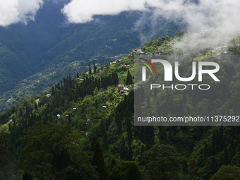 Small villages are being seen through clouds inside Singalila National Park in Darjeeling District, West Bengal, India, on June 29, 2024. (