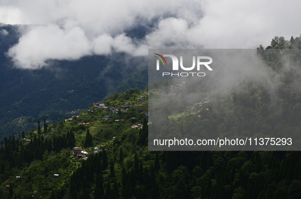 Small villages are being seen through clouds inside Singalila National Park in Darjeeling District, West Bengal, India, on June 29, 2024. 