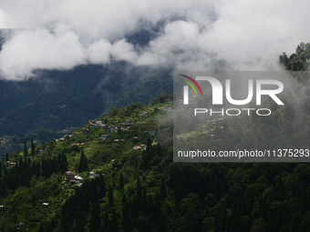 Small villages are being seen through clouds inside Singalila National Park in Darjeeling District, West Bengal, India, on June 29, 2024. (