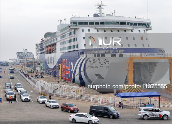 Vehicles are entering a passenger ship bound for Dalian at the port of Yantai in Yantai, China, on July 1, 2024. 