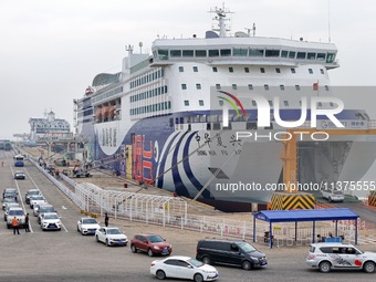 Vehicles are entering a passenger ship bound for Dalian at the port of Yantai in Yantai, China, on July 1, 2024. (