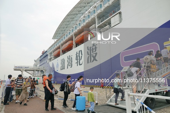 Passengers are taking a boat to Dalian at Yantai Port in Yantai, China, on July 1, 2024. 