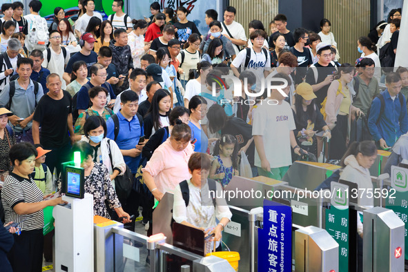 Passengers are queuing to check for tickets at Nanjing Railway Station in Nanjing, China, on July 1, 2024. 