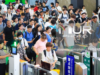 Passengers are queuing to check for tickets at Nanjing Railway Station in Nanjing, China, on July 1, 2024. (