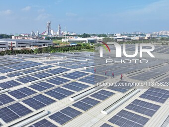 Power technicians are inspecting the operation of rooftop solar photovoltaic modules in Chuzhou, China, on June 30, 2024. (