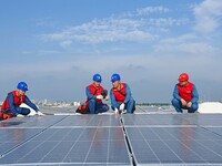 Power technicians are inspecting the operation of rooftop solar photovoltaic modules in Chuzhou, China, on June 30, 2024. (