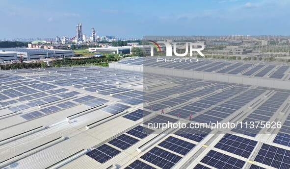 Power technicians are inspecting the operation of rooftop solar photovoltaic modules in Chuzhou, China, on June 30, 2024. 