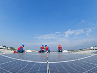 Power technicians are inspecting the operation of rooftop solar photovoltaic modules in Chuzhou, China, on June 30, 2024. (