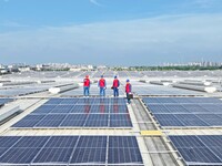 Power technicians are inspecting the operation of rooftop solar photovoltaic modules in Chuzhou, China, on June 30, 2024. (