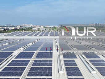 Power technicians are inspecting the operation of rooftop solar photovoltaic modules in Chuzhou, China, on June 30, 2024. (