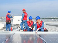 Power technicians are inspecting the operation of rooftop solar photovoltaic modules in Chuzhou, China, on June 30, 2024. (