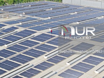 Power technicians are inspecting the operation of rooftop solar photovoltaic modules in Chuzhou, China, on June 30, 2024. (