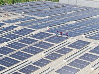 Power technicians are inspecting the operation of rooftop solar photovoltaic modules in Chuzhou, China, on June 30, 2024. (