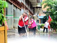 Villagers are removing silt formed by heavy rain in Congjiang county, Qiandongnan Miao and Dong autonomous prefecture, Southwest China's Gui...