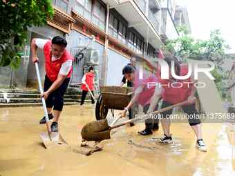 Villagers are removing silt formed by heavy rain in Congjiang county, Qiandongnan Miao and Dong autonomous prefecture, Southwest China's Gui...