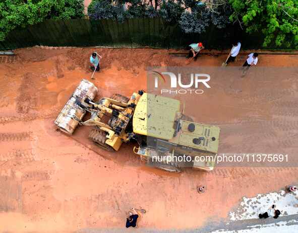 Villagers are removing silt formed by heavy rain in Congjiang county, Qiandongnan Miao and Dong autonomous prefecture, Southwest China's Gui...