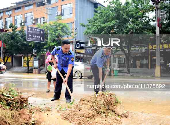 Villagers are removing silt formed by heavy rain in Congjiang county, Qiandongnan Miao and Dong autonomous prefecture, Southwest China's Gui...