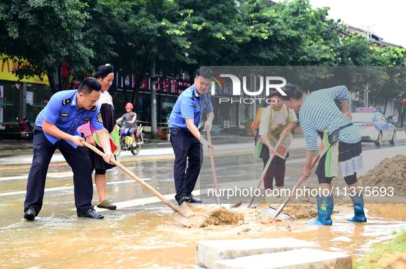 Villagers are removing silt formed by heavy rain in Congjiang county, Qiandongnan Miao and Dong autonomous prefecture, Southwest China's Gui...