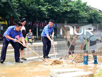 Villagers are removing silt formed by heavy rain in Congjiang county, Qiandongnan Miao and Dong autonomous prefecture, Southwest China's Gui...