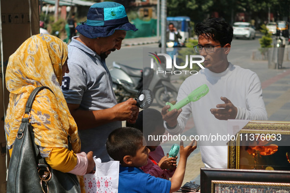 People are buying battery fans on a hot summer day in Srinagar, Jammu and Kashmir, on July 01, 2024. 