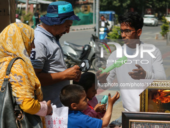 People are buying battery fans on a hot summer day in Srinagar, Jammu and Kashmir, on July 01, 2024. (