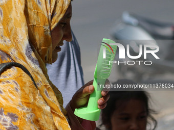 A woman is cooling off herself with a battery fan on a hot summer day in Srinagar, Jammu And Kashmir, on July 01, 2024. (