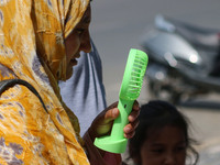 A woman is cooling off herself with a battery fan on a hot summer day in Srinagar, Jammu And Kashmir, on July 01, 2024. (