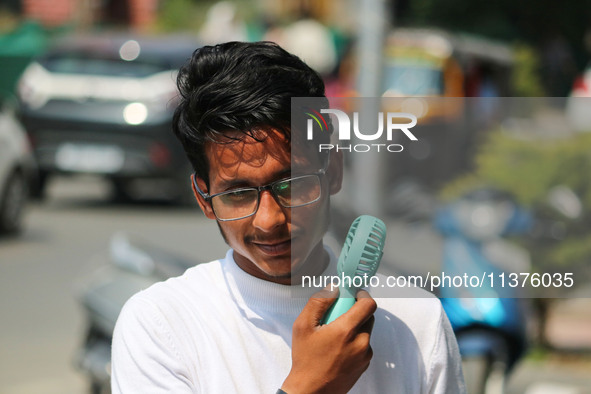 A man is cooling off with a battery fan on a hot summer day in Srinagar, Jammu and Kashmir, on July 01, 2024. 