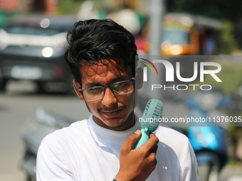 A man is cooling off with a battery fan on a hot summer day in Srinagar, Jammu and Kashmir, on July 01, 2024. (